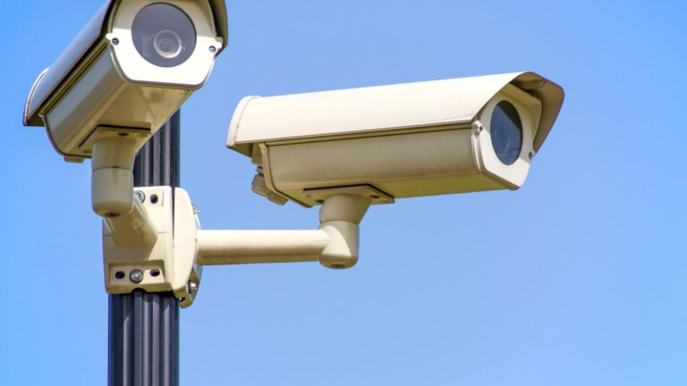 White CCTV tower surveilling on a street