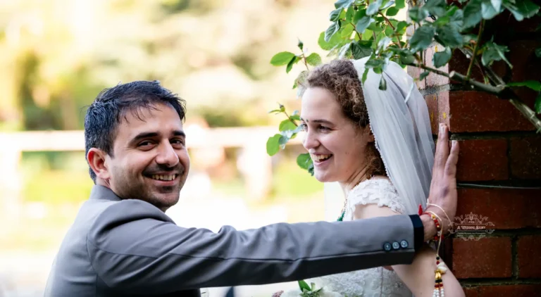 joyful-wedding-groom-smiling-bride-laughing-brick-wall